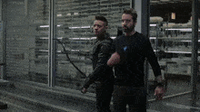a man in an iron man suit is standing next to another man in a black jacket