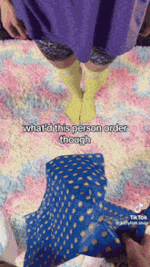 a person wearing yellow knee high socks is standing on a pink and blue rug ..