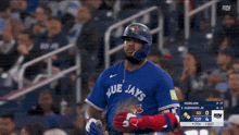 a baseball player for the blue jays stands in front of a crowd