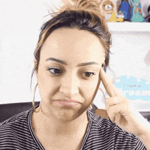 a woman in a striped shirt is making a funny face