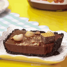a piece of chocolate pie on a plate with mr.cakes written on the bottom right
