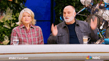 a man and a woman are sitting at a table with a nbc logo on the bottom right