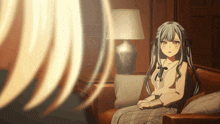 a girl sitting on a couch with a lamp behind her