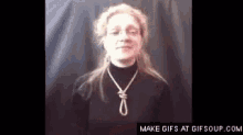 a woman wearing a black shirt and a necklace with a rope around her neck .