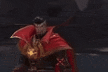 a man in a red cape is standing in a dark room with a green light in the background .