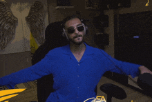 a man wearing headphones and sunglasses is sitting in front of a samsung monitor