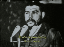 a man speaking into a microphone with the words or who had been fighting for his freedom below him