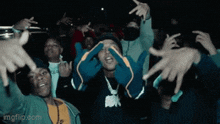 a group of people with their hands in the air including one wearing a shirt that says ' mafia ' on it