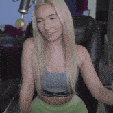 a woman wearing a crop top that says crooks & caffeine sits in front of a microphone