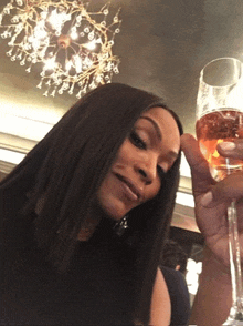a woman is holding a glass of wine in her hand