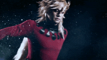 a person in a red shirt with a long blonde hair