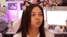 a woman wearing cat ears looks at the camera