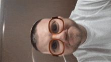 a man wearing glasses and a white shirt is smiling