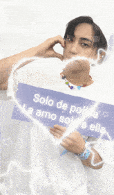 a man holding a sign that says solo de polloa la amo solo a elle