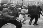 a black and white photo of a group of people dancing in front of a sign that says no parking