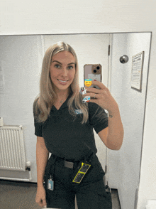 a woman taking a selfie in front of a mirror with a phone case that says ' emoji ' on it