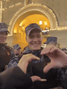a group of people making a heart shape with their hands
