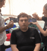 a boy wearing a shirt that says ' sol ent ' on it is being photographed