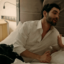 a man in a white shirt is laying on a bed with a woman