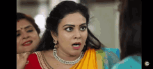 a woman in a yellow saree is making a funny face with her mouth open