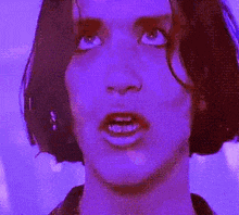 a close up of a woman 's face with a purple background
