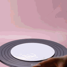 a person 's hand is reaching for a cake on a black plate that says tincakes on the bottom