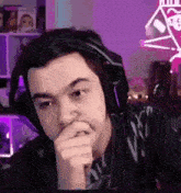 a man wearing headphones is sitting in front of a computer and making a funny face .