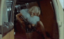 a woman in a blue fur coat is sitting in a van