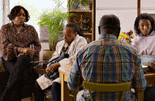a group of people are sitting around a table talking