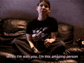 a woman sits on a couch with the words " when i 'm with you i 'm this amazing person " above her