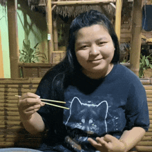 a woman wearing a black shirt with a cat on it