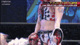 a woman in a wrestling outfit is standing in front of a stardom logo