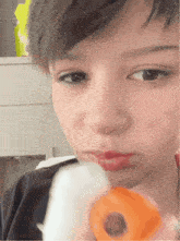 a girl with a nose ring is holding a toy