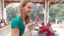 a woman in a kitchen with a red mixer says " yeah "