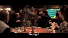 a group of people are gathered around a table with the words enough on the bottom