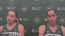 two female basketball players stand in front of a providence swedish wall