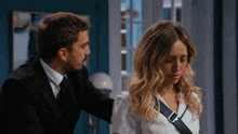 a man in a suit and tie is comforting a woman