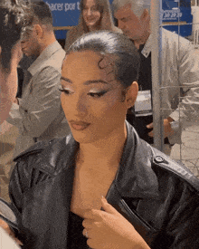 a woman in a leather jacket is talking to a man