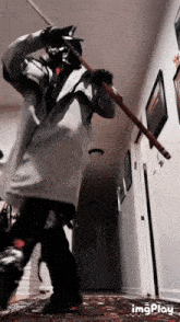 a person holding a stick in a hallway with the words imgplay below