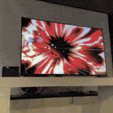 a flat screen tv with a red flower on it