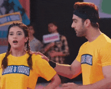 a man and a woman are wearing yellow shirts that say yoddhas on them
