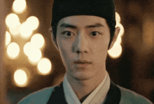 a close up of a man wearing a hat looking at the camera