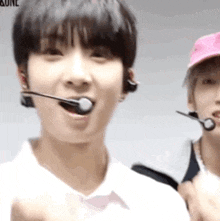 a close up of a person wearing a microphone in their mouth and a man wearing a pink hat .