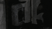 a person in a dark room with a blue light coming out of the corner