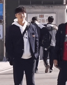 a group of people are walking in front of a building with a sign that says ' 고동 ' on it