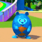 a blue cartoon character is standing in front of a slide and holding a piece of food .