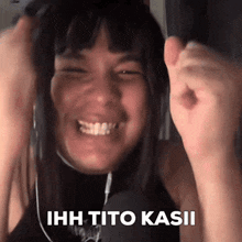 a woman is wearing headphones and smiling with her fist in the air and the words ihh tito kasii on the bottom