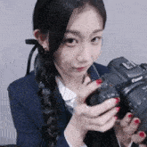 a young woman holding a canon camera in her hands