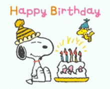 snoopy is wearing a party hat and sitting next to a birthday cake .