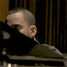 a man covering his face with a black cloth
